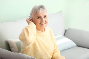 Senior woman with hearing aid at home