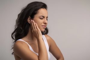 Tinnitus. Profile of sick brunette young woman